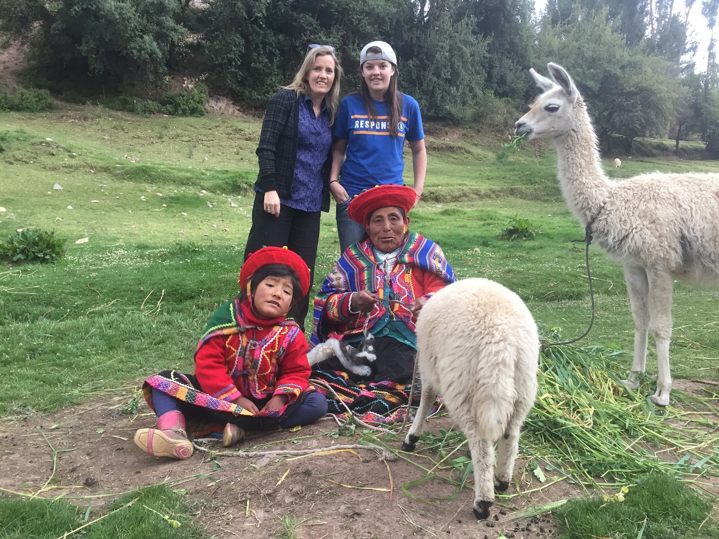 Cusco-city-tour-posing-with-Grandma-and-child-and-Llamas
