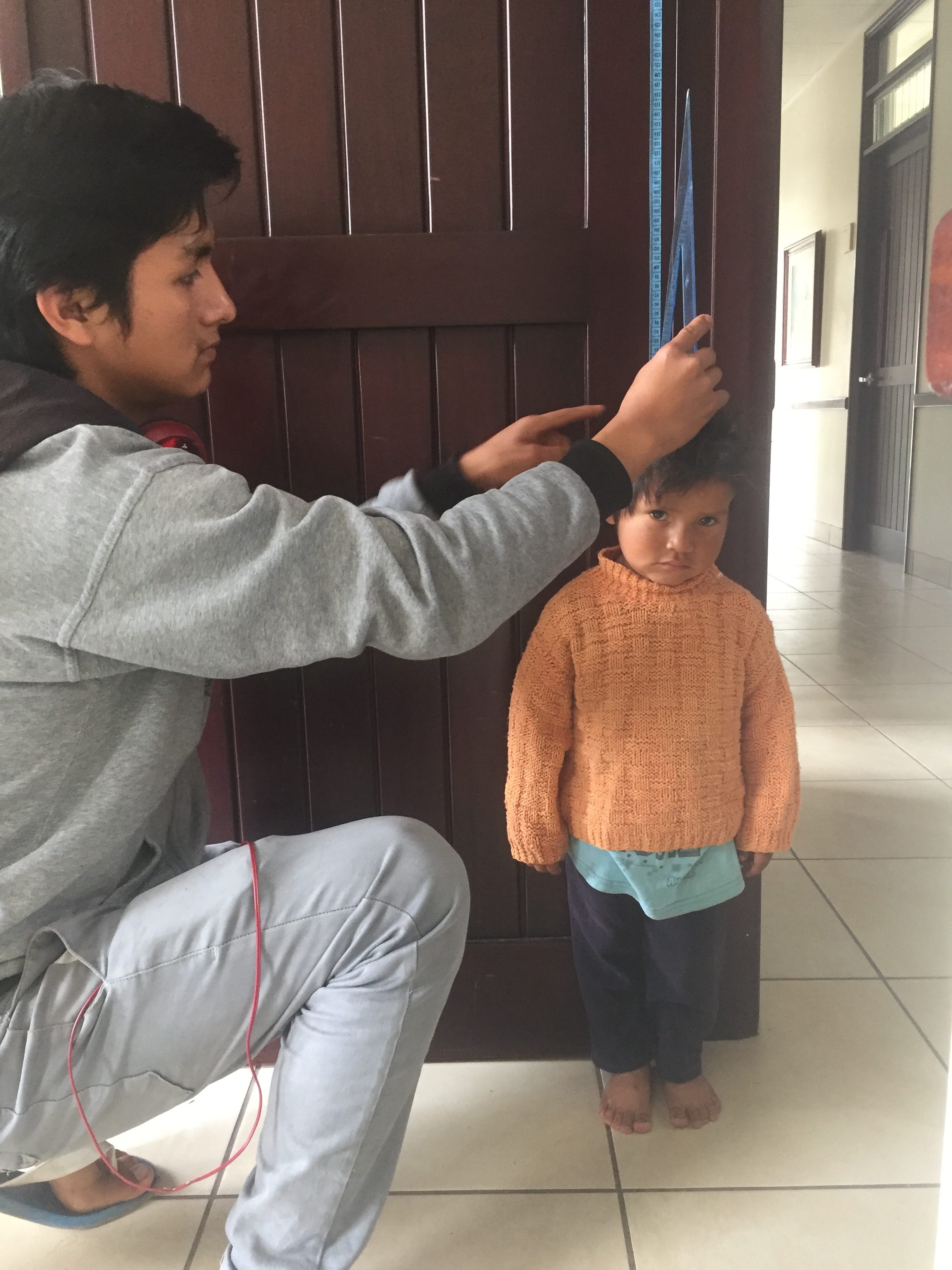 Urubamba-screening-young-man-preparing-for-a-mission-measures-a-boy